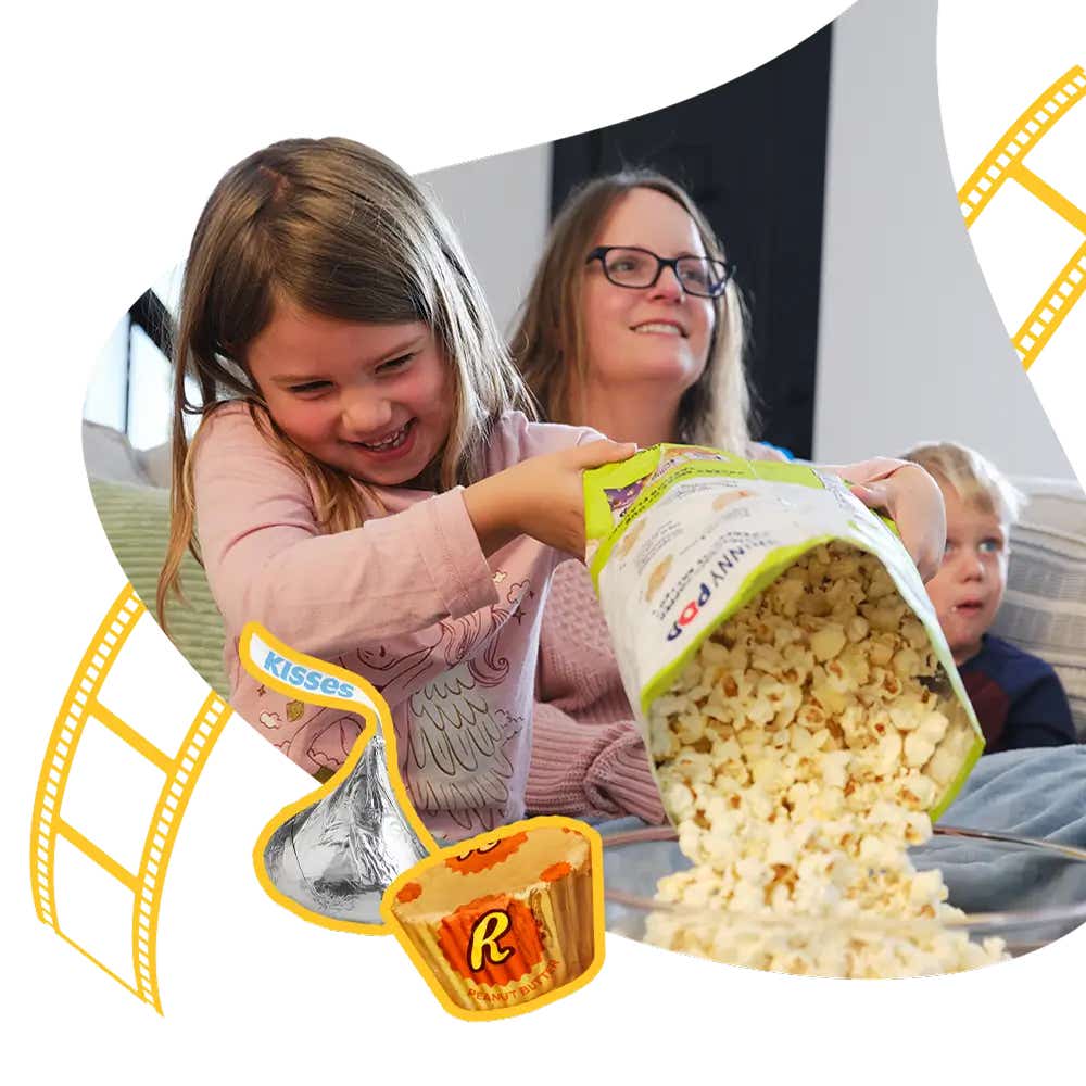 smiling family sitting on couch with hersheys kisses and reeses peanut butter cups