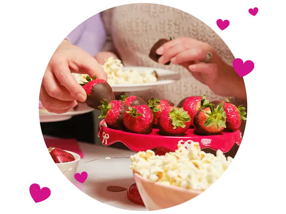 people enjoying chocolate dipped strawberries and salty snacks